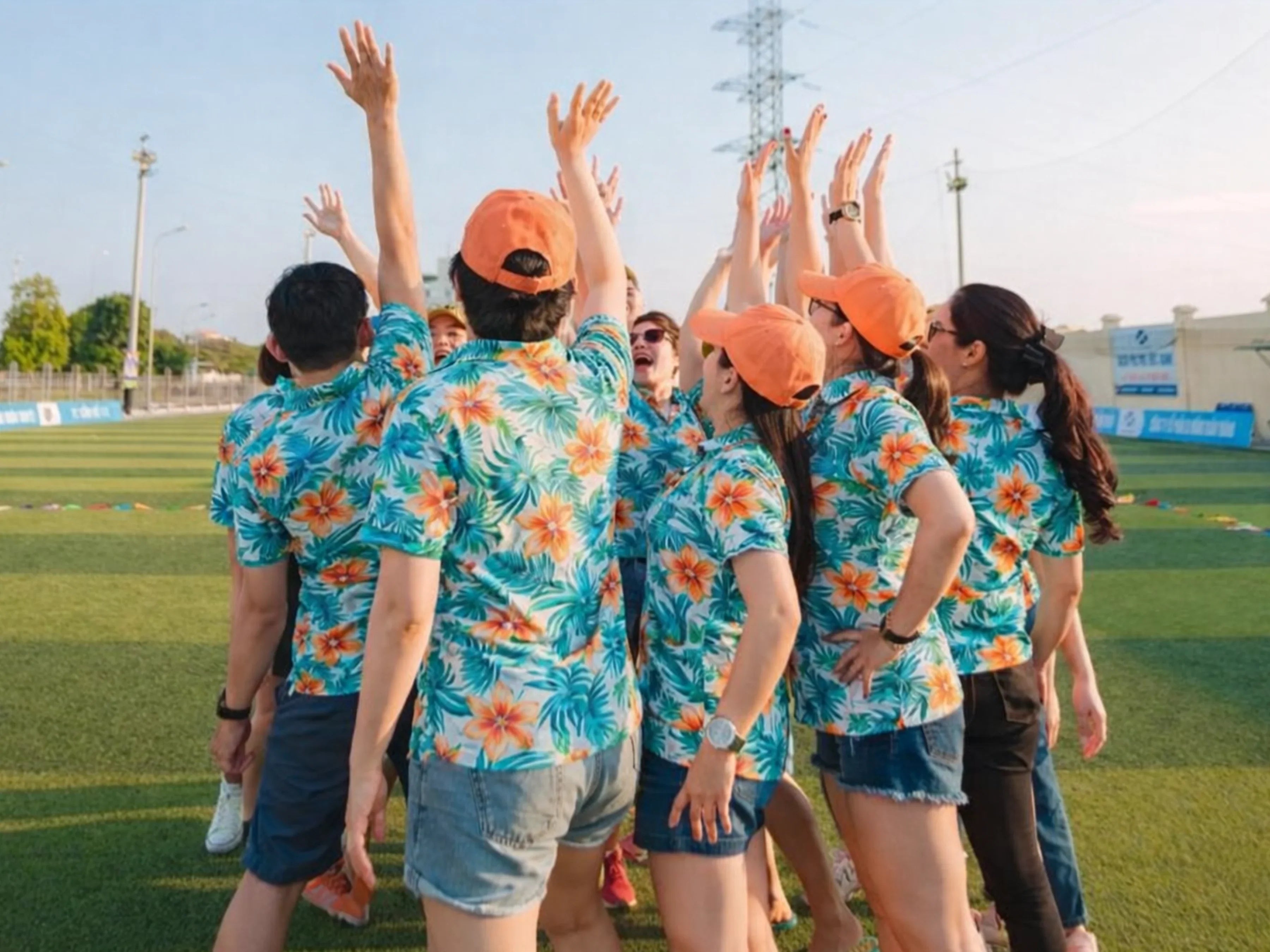Team members wearing matching Hawaiian shirts in coordinated tropical patterns during an outdoor team building activity