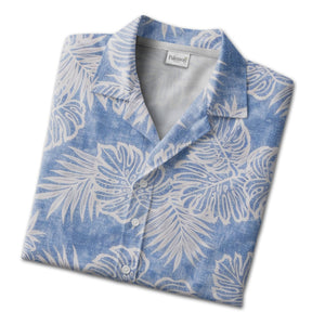 Textured blue Hawaiian shirt with monstera leaves and palm fronds in white outline art